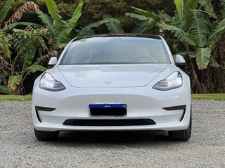 Foto de um tesla model 3 igual a zero.